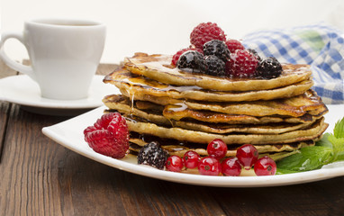 Delicious pancakes with berries and maple syrup