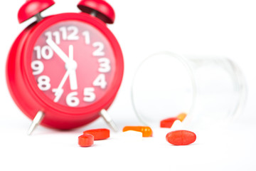 Medicine tablet, dispensing glass and red clock show medicine time