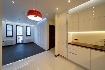 The drawing room with a dark floor passing into kitchen