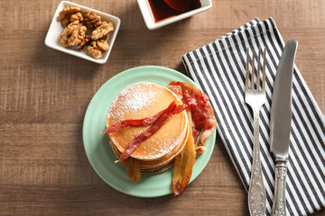 Tasty pancakes with bacon and banana on table