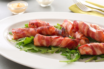 Plate with bacon wrapped chicken nuggets on table, closeup