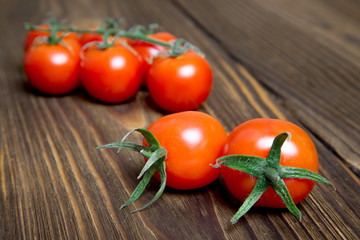 Ripe tomatoes on dark wooden background © malika21