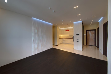 A drawing room with the built-in kitchen with a white floor and lamps