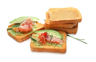Delicious sandwiches with salmon fillet and avocado on white background