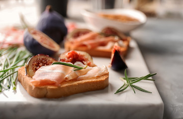 Delicious sandwich with lunch meat and fig on board, closeup
