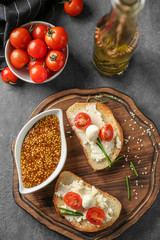 Delicious sandwiches with cherry tomatoes and mozzarella on wooden board, top view