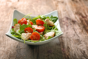 Bowl with delicious vegetable salad on wooden background
