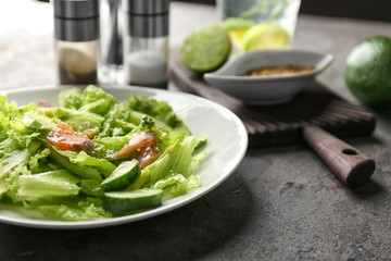 Plate with delicious fresh salad on table, closeup