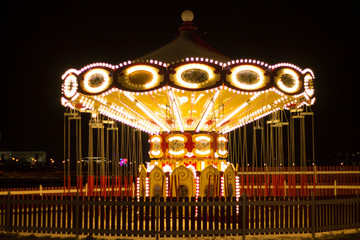vintage carousel decorated with bright lights in the winter night