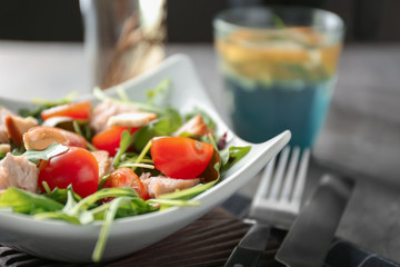 Bowl with delicious fresh salad on table, closeup