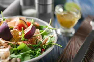 Bowl with delicious fresh salad on table, closeup