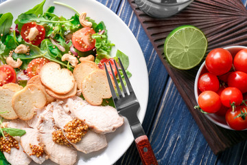 Plate with meat and delicious fresh salad on table