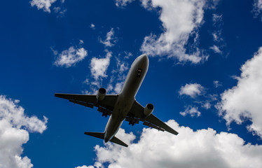 The plane on a background of blue sky and white clouds.