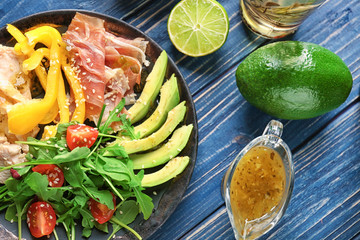 Plate with meat and delicious fresh salad on table, top view