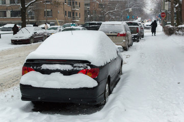Major snow storm and blizzard beating through Quebec, accumulating snow piling up against parked...