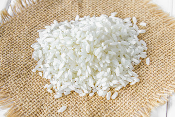 Grains of raw white rice on a white wooden table of boards. Ingredients for cooking.