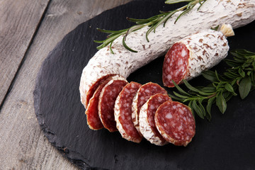 Stone cutting board with sliced salami on it