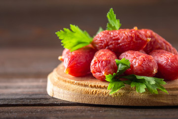 Small smoked sausages on a wooden table.