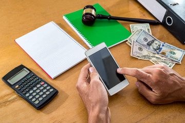 hand with phone and dollars on desk