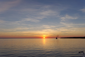 Obraz premium A view of the calm golden sunset on the river with the sun reflected in it, Volga, Russia