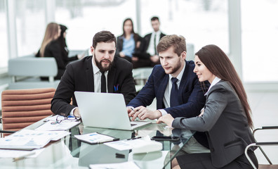 confident business team working on laptop with financial records
