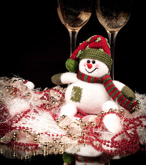 fun toy snowman and two glasses of champagne on a black backgro
