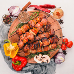 Marinated baked kebab with onions and spices. On a wooden background. Top view. Free space for text.
