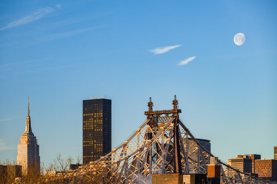 Early morning New York City (Manhattan) skyline with the Queensboro Bridge and waning gibbous moonset