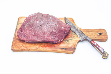 Raw beef stak on a chopping board. The isolated object on a white background