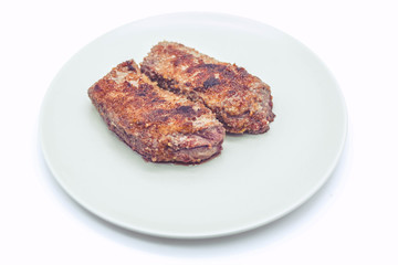 Grilled beef stakes on a big plate. Object on a light background
