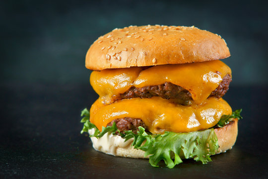 Burger with cheese and bacon on a dark background