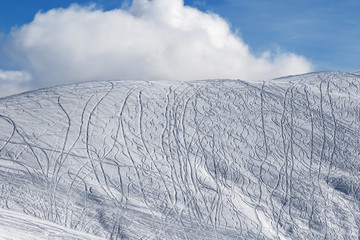 Snowy off-piste slope for freeride with traces from skis, snowboards
