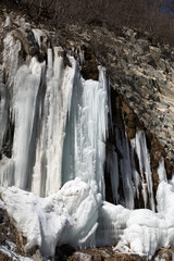 Fototapeta na wymiar Icy mountain waterfall at nice sun day