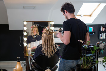 Hairdresser and blonde cliente at salon