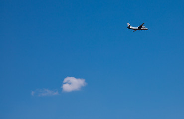Aeroplane and white cloud on blu sky. Travel Concept.