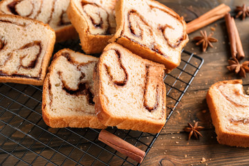 Baking rack with delicious cinnamon roll cake on table
