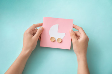 Woman holding Thank you card for baby shower party on color background