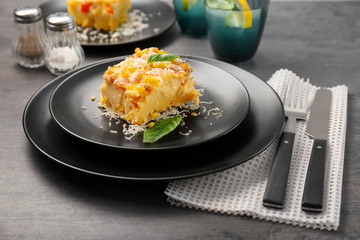 Plate with piece of corn pudding on table