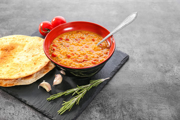 Bowl with tasty lentil soup on slate plate