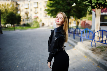 Elegant blonde girl wear on black leather jacket posing at streets of town.