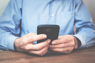 Businessman using smartphone in his desk.