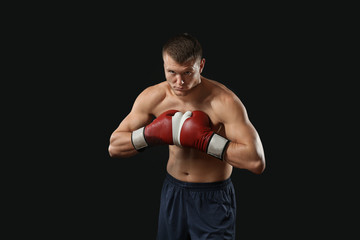 Fototapeta na wymiar Attractive young boxer on black background