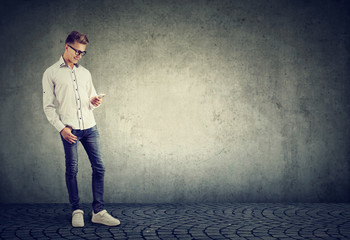 Casual man with phone on gray