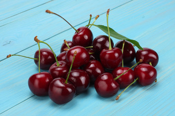 cherry in bowl on blue wooden background
