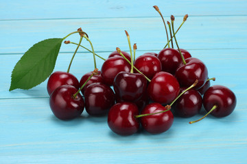 cherry in bowl on blue wooden background