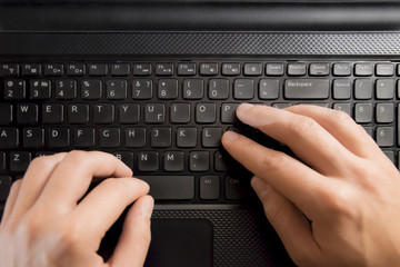 Fingers pressing keyboard key on laptop. Hands with computer