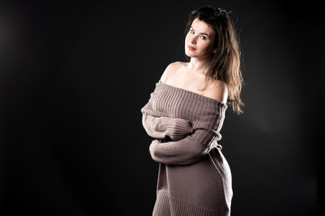 Beautiful sensitive woman in warm knitted dress, copy space