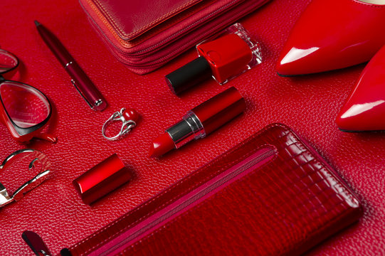 Red woman accessories, jewelry, cosmetic, shoes and other objects on leather background, fashion industry, modern female concept, selective focus 