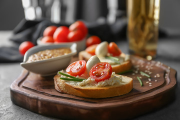 Delicious sandwich with cherry tomato and mozzarella on wooden board, closeup