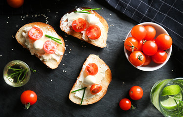 Delicious sandwiches with cherry tomatoes and mozzarella on table, top view